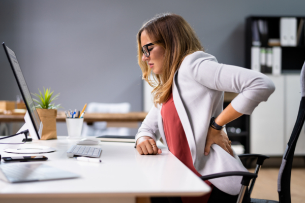 femme assise au bureau avec des maux de dos